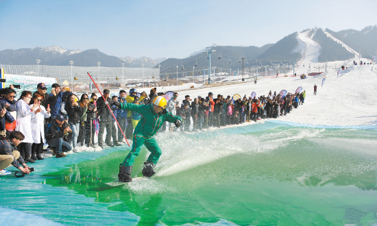 上圖為3月24日，在絲綢之路國(guó)際度假區(qū)滑雪場(chǎng)，滑雪愛(ài)好者在體驗(yàn)雪地滑水。