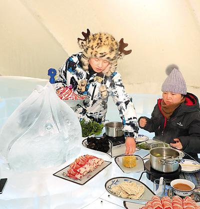 游客在哈爾濱冰雪大世界園區(qū)“冰屋”品味“冰火鍋”