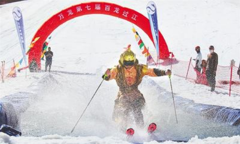 5月1日，萬龍滑雪場第七屆“百龍過江”活動現(xiàn)場，一名選手滑過水池。