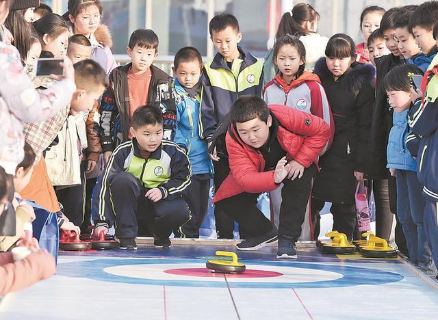 在省首屆冰雪運動會上，孩子們體驗陸地冰壺。