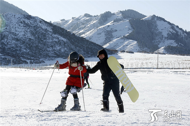 在白云國(guó)際滑雪場(chǎng)內(nèi)，一位初學(xué)者在同伴的攙扶下學(xué)習(xí)滑雪。